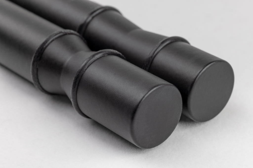 Close-up of a pair of Winepegs Nek Rite 1 lite wall-mounted black wine pegs with silicone o-rings for secure bottle holding