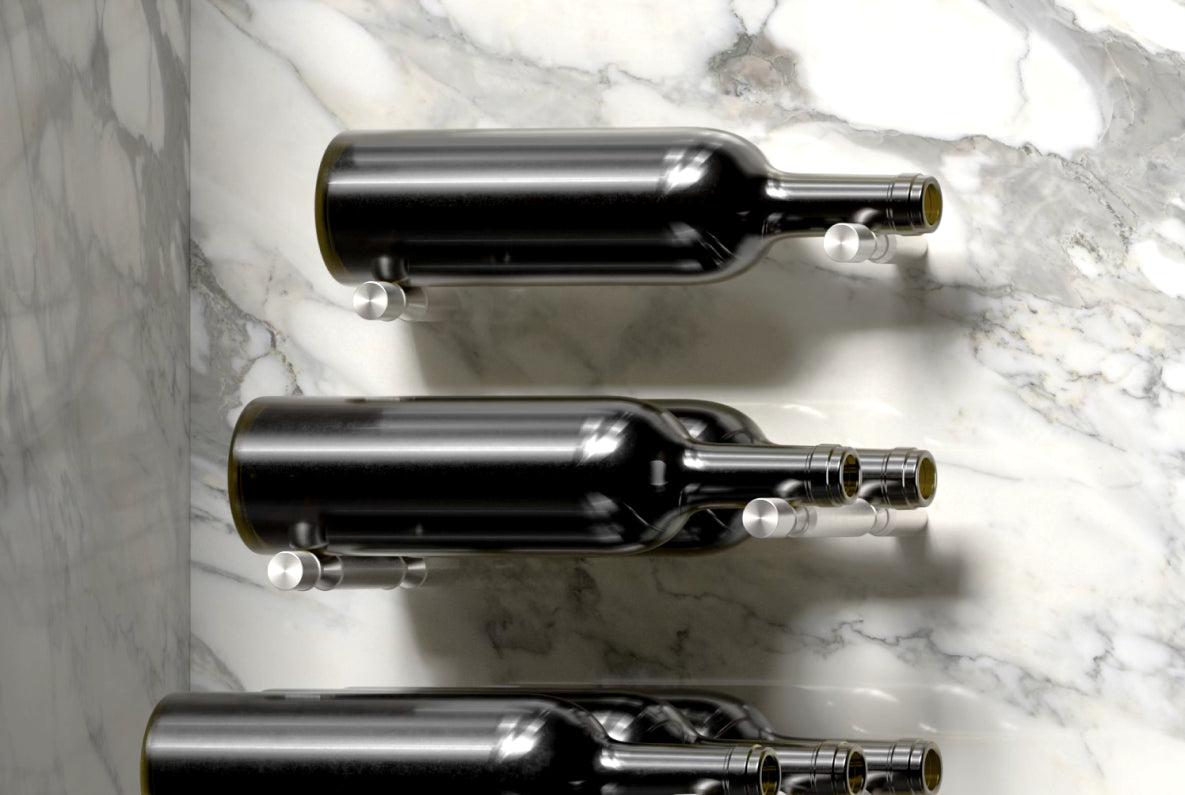 Wall-mounted metal wine bottle holders by Wine Pegs displaying 12 bottles on a marble wall